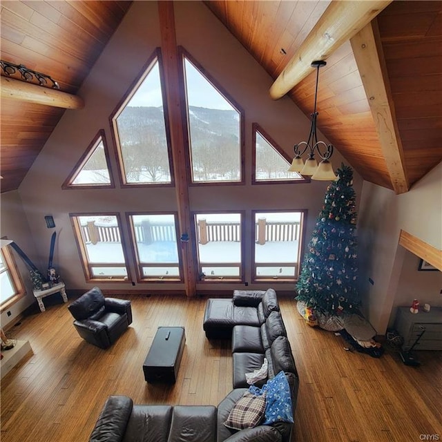 living area featuring wooden ceiling, hardwood / wood-style flooring, a chandelier, and beamed ceiling