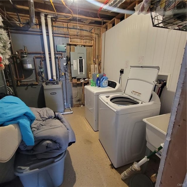 laundry room featuring laundry area, electric panel, a sink, and washer and clothes dryer