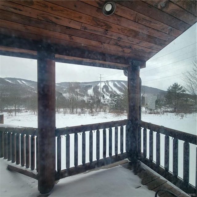 snow covered deck featuring a mountain view