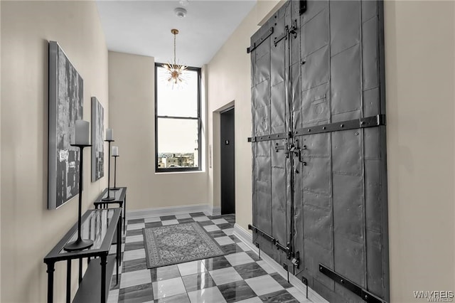 interior space with baseboards, a barn door, and tile patterned floors