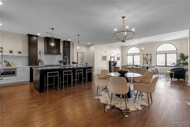 dining area with baseboards, dark wood-style flooring, recessed lighting, and an inviting chandelier