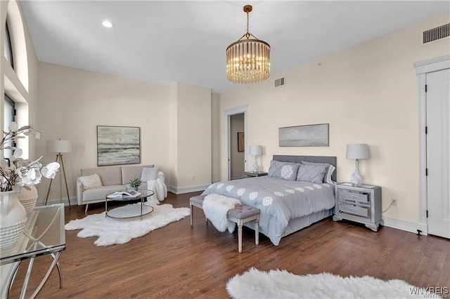 bedroom with dark wood-style flooring, an inviting chandelier, visible vents, and baseboards