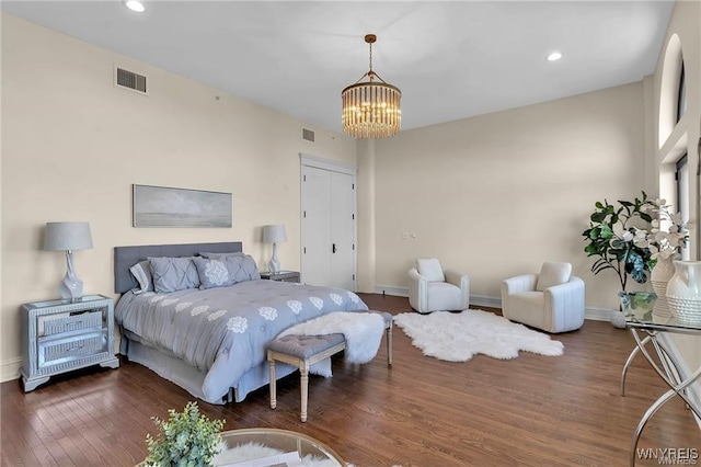 bedroom with baseboards, visible vents, dark wood finished floors, and a notable chandelier