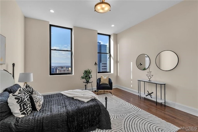 bedroom with dark wood-style floors, baseboards, and recessed lighting