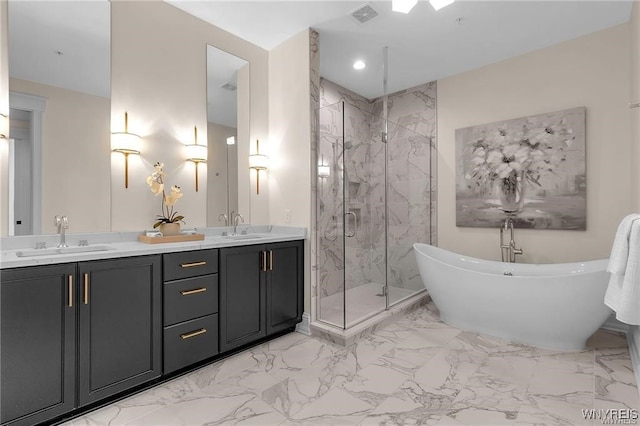 full bath with marble finish floor, a freestanding tub, a sink, and visible vents