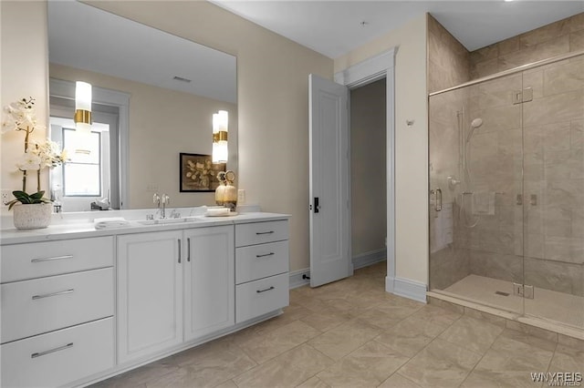 bathroom with visible vents, a stall shower, vanity, and baseboards