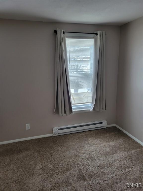 unfurnished room featuring a baseboard radiator, carpet flooring, and baseboards