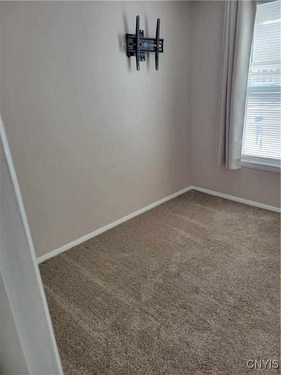 carpeted empty room with baseboards