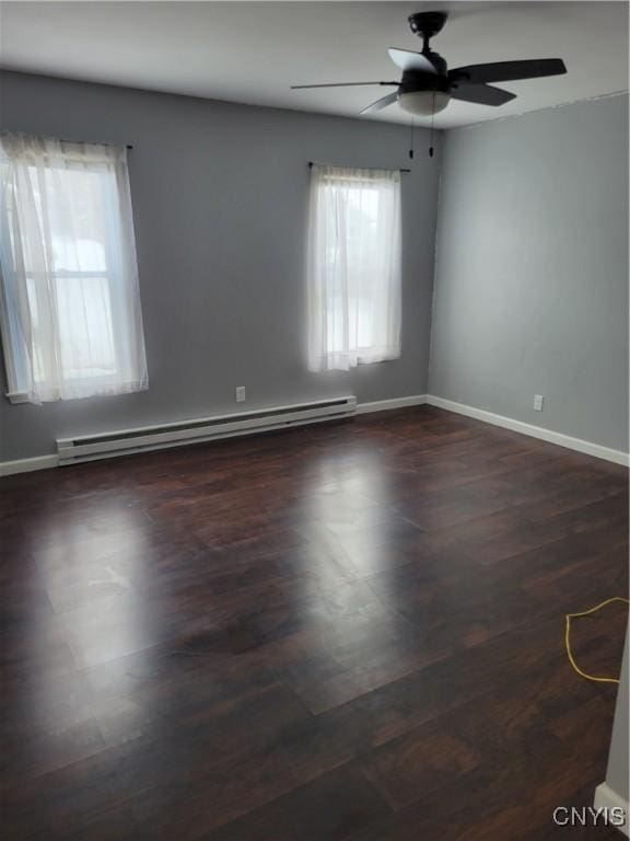 unfurnished room featuring dark wood-style floors, a baseboard radiator, baseboards, and a ceiling fan