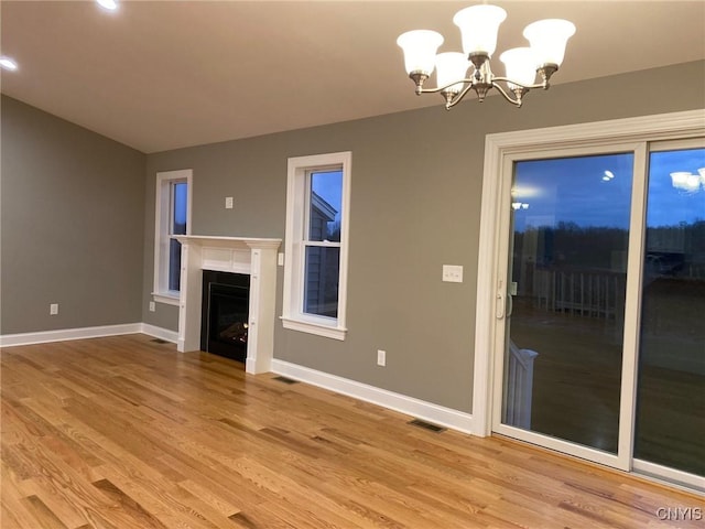 unfurnished living room featuring light wood-style floors, a fireplace, and baseboards