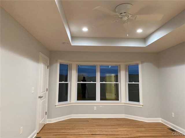 empty room featuring a ceiling fan, recessed lighting, baseboards, and wood finished floors