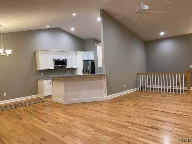 kitchen featuring a peninsula, appliances with stainless steel finishes, dark countertops, and white cabinets