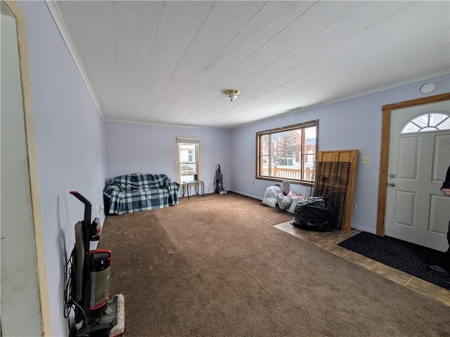 carpeted entryway with baseboards and ornamental molding