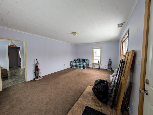 interior space featuring crown molding, visible vents, and dark carpet