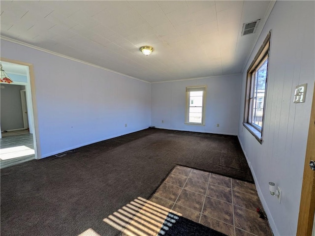 unfurnished room featuring baseboards, visible vents, dark carpet, and ornamental molding