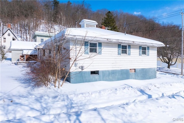 view of snow covered exterior featuring a chimney