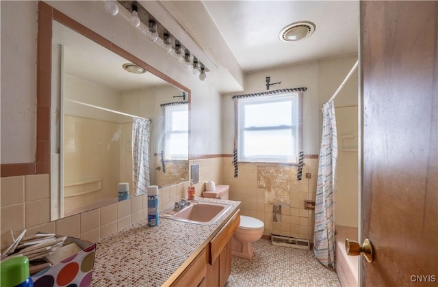 full bath featuring a wainscoted wall, tile walls, toilet, shower / bath combo with shower curtain, and vanity