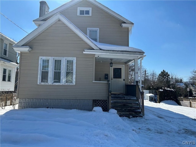 view of front of property featuring a chimney and fence