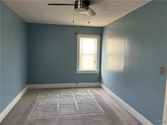 spare room featuring ceiling fan, baseboards, and light colored carpet