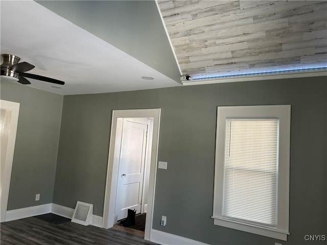 spare room with a ceiling fan, baseboards, and dark wood-style flooring