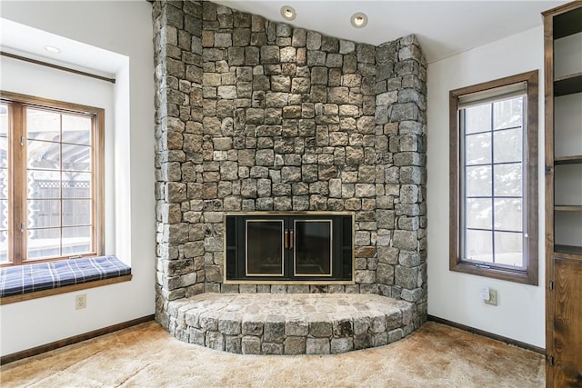 interior details featuring a large fireplace, carpet, and baseboards