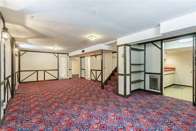 finished basement featuring carpet, visible vents, and a textured ceiling