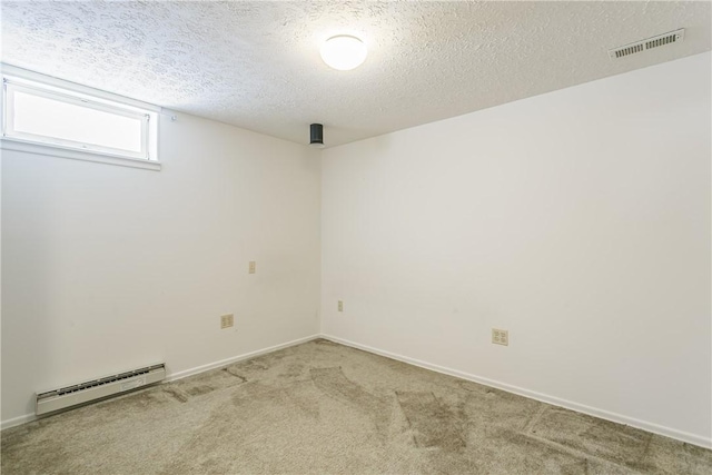 carpeted empty room featuring a baseboard radiator, visible vents, a textured ceiling, and baseboards