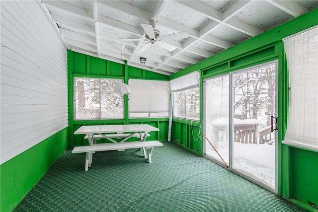 unfurnished sunroom with a ceiling fan, plenty of natural light, and lofted ceiling with beams