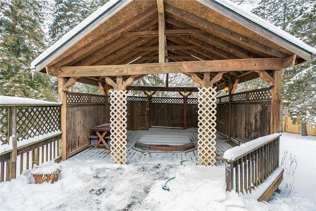 snow covered deck featuring a covered hot tub