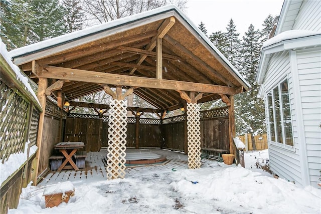 snow covered patio with fence and a gazebo