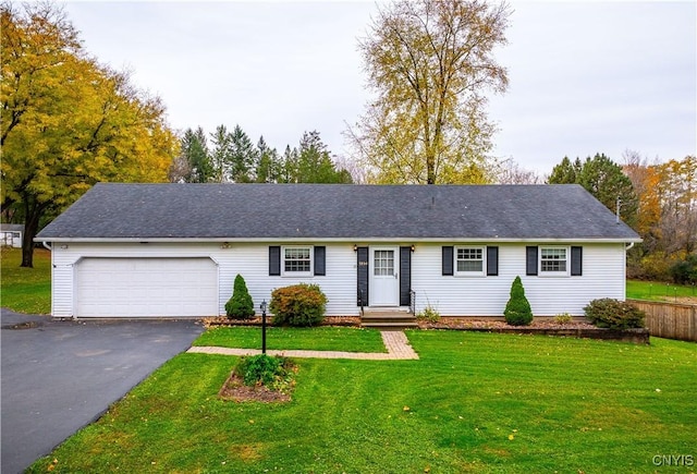 ranch-style house featuring an attached garage, driveway, and a front lawn