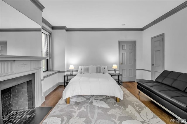 bedroom with ornamental molding, dark wood-style flooring, a fireplace, and baseboards