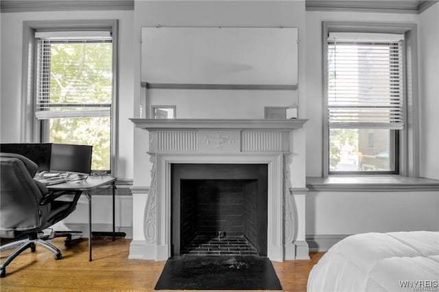 bedroom featuring a fireplace and wood finished floors