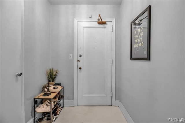 doorway featuring baseboards