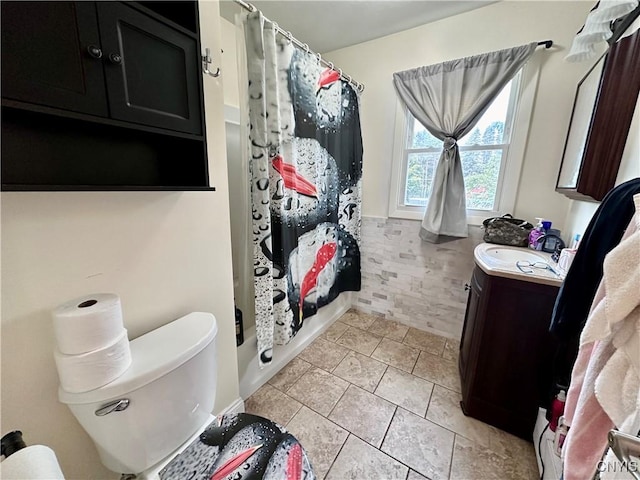 bathroom with toilet, tile patterned flooring, shower / bath combo with shower curtain, and vanity