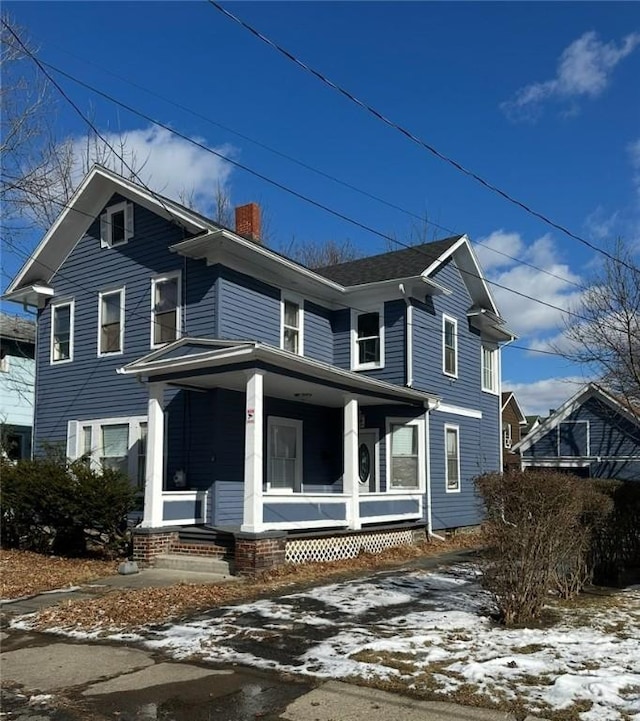 view of front of house featuring a porch and a chimney