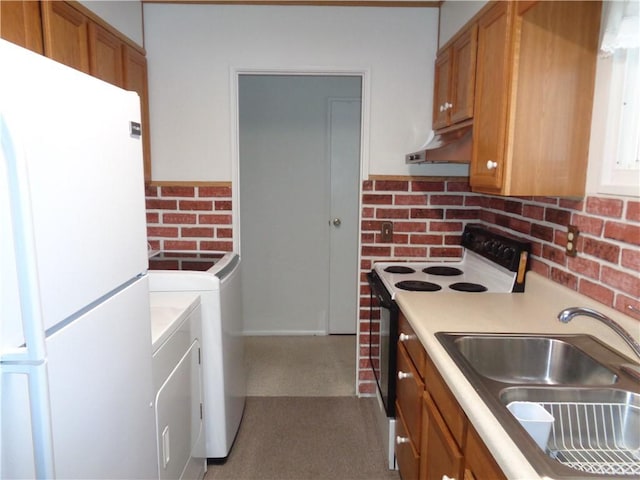 kitchen featuring washer and dryer, light countertops, range with electric stovetop, and freestanding refrigerator