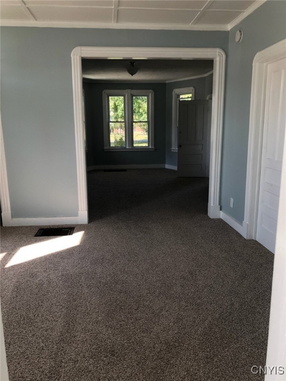 empty room with visible vents, dark carpet, and baseboards