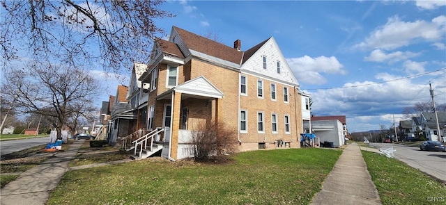 view of home's exterior featuring a yard, brick siding, and a residential view