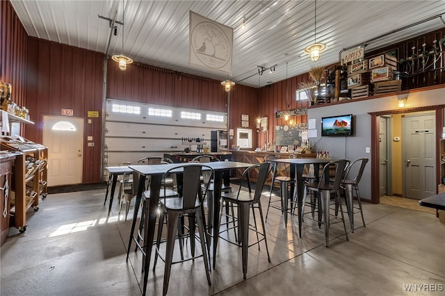 interior space featuring wooden walls and finished concrete flooring