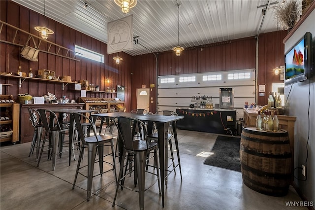 bar featuring finished concrete flooring and wooden walls