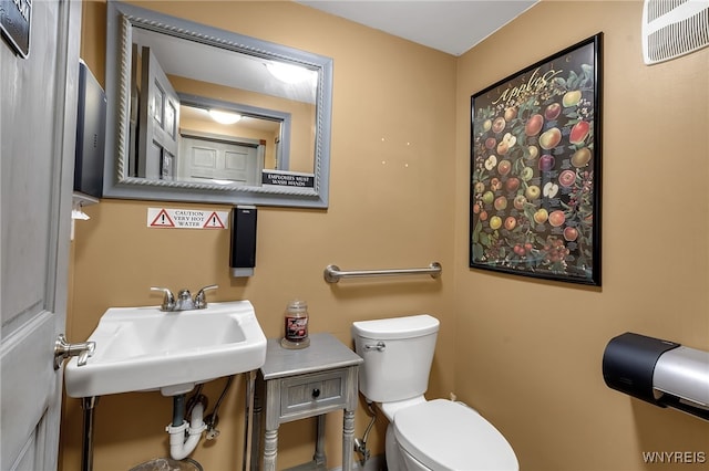 bathroom with visible vents, a sink, and toilet