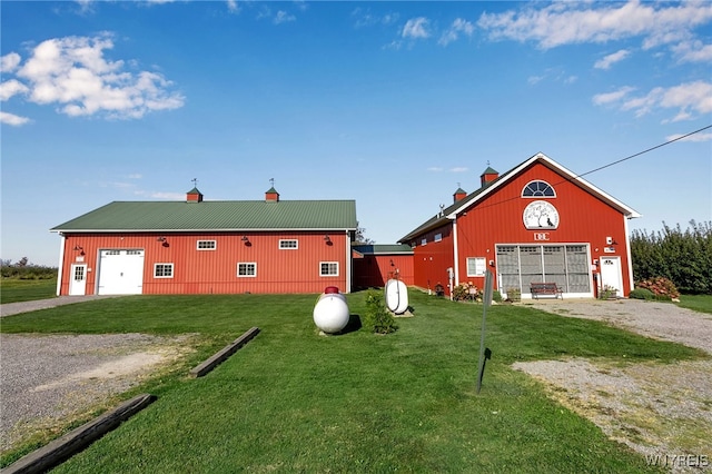 exterior space with a yard, an outbuilding, an outdoor structure, and a detached garage