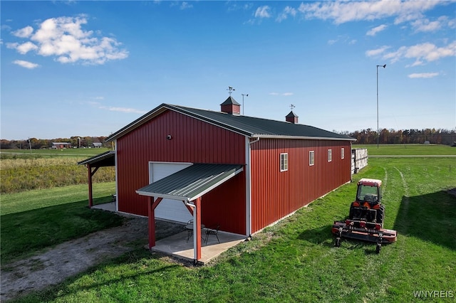 view of pole building with driveway and a lawn