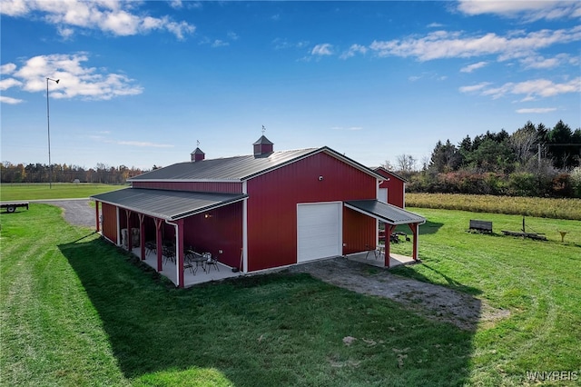 view of pole building featuring driveway and a yard