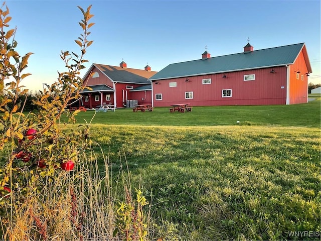 rear view of house with metal roof and a yard