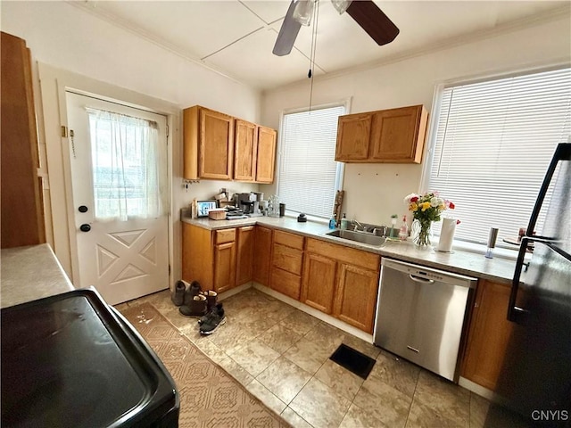 kitchen with dishwasher, light countertops, a sink, and brown cabinets