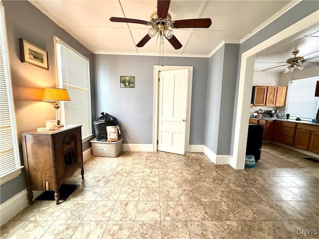 interior space featuring baseboards, ornamental molding, and a ceiling fan