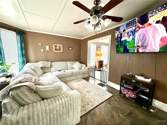 living room with crown molding, ceiling fan, finished concrete flooring, and baseboards