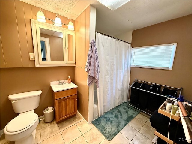 bathroom with toilet, vanity, and tile patterned floors